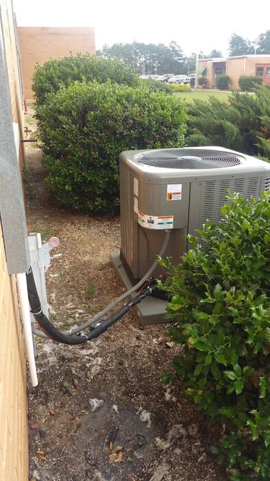 Residential condenser set beside a brick home