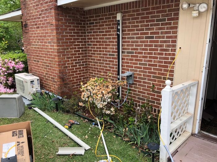 Mini-split install in progress at a brick home